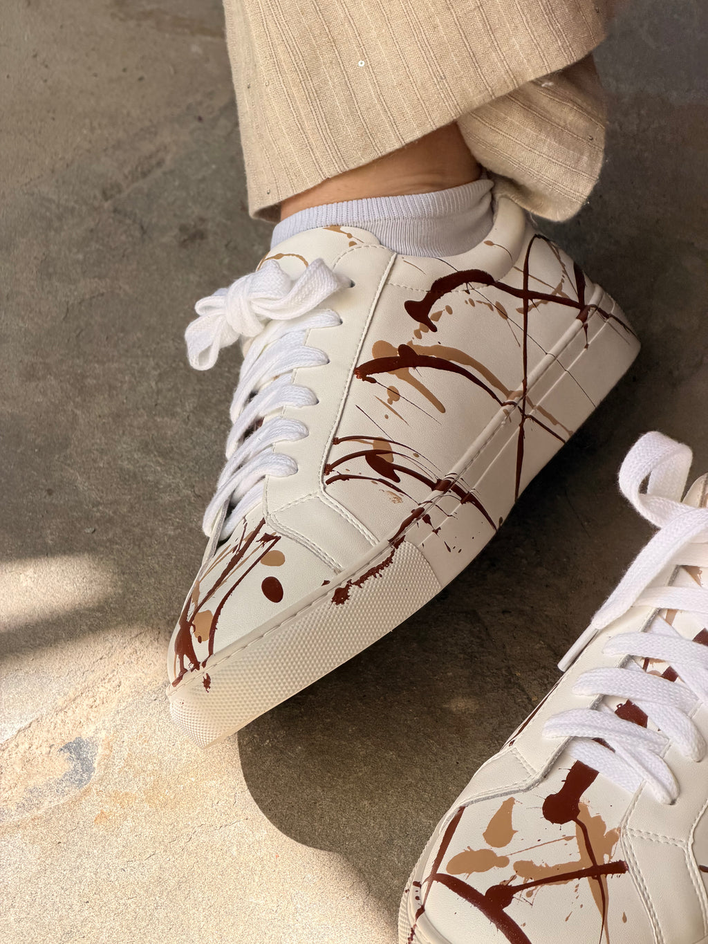 Handbemalter weißer Leder-Sneaker mit champanger-sattelbraunen Farbspritzern
